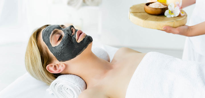 woman relaxing with a mud face mask