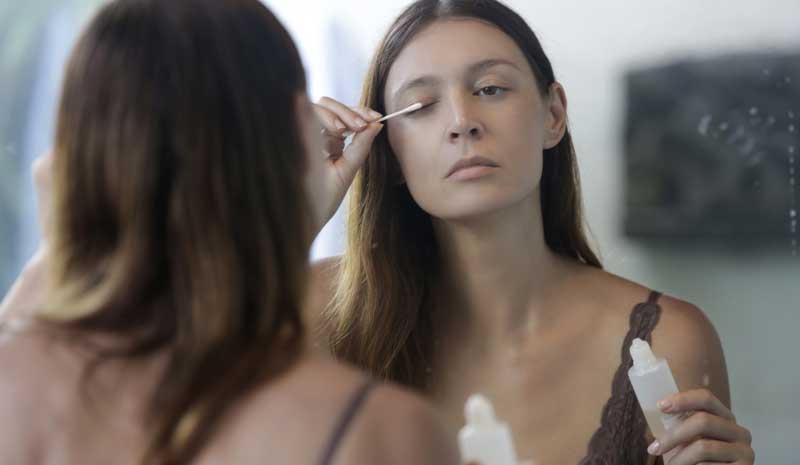 woman applying some homemade eyelash growth serum 
